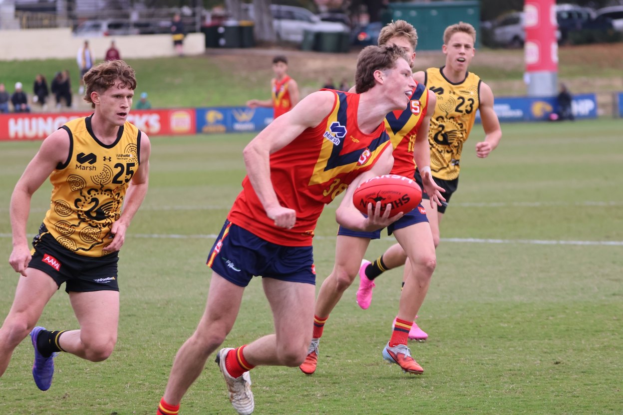 Players contesting the ball under stadium lights